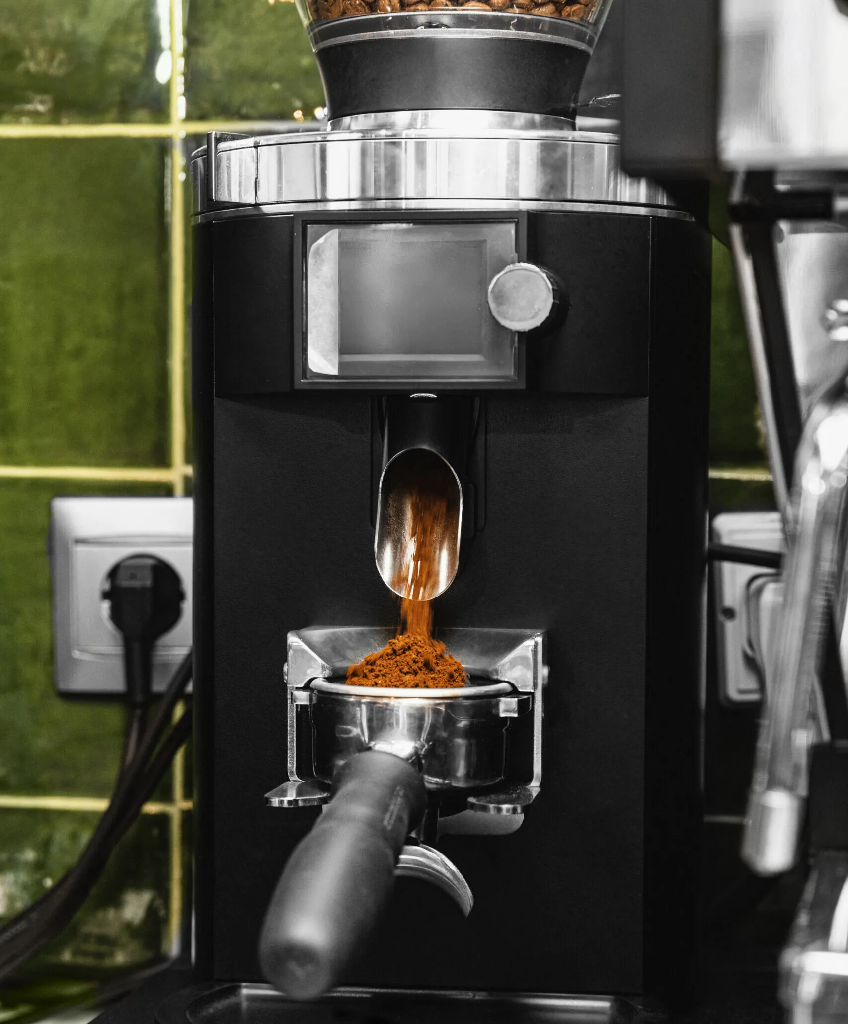 Coffee machine grinder dosing freshly ground coffee beans into a portafilter
