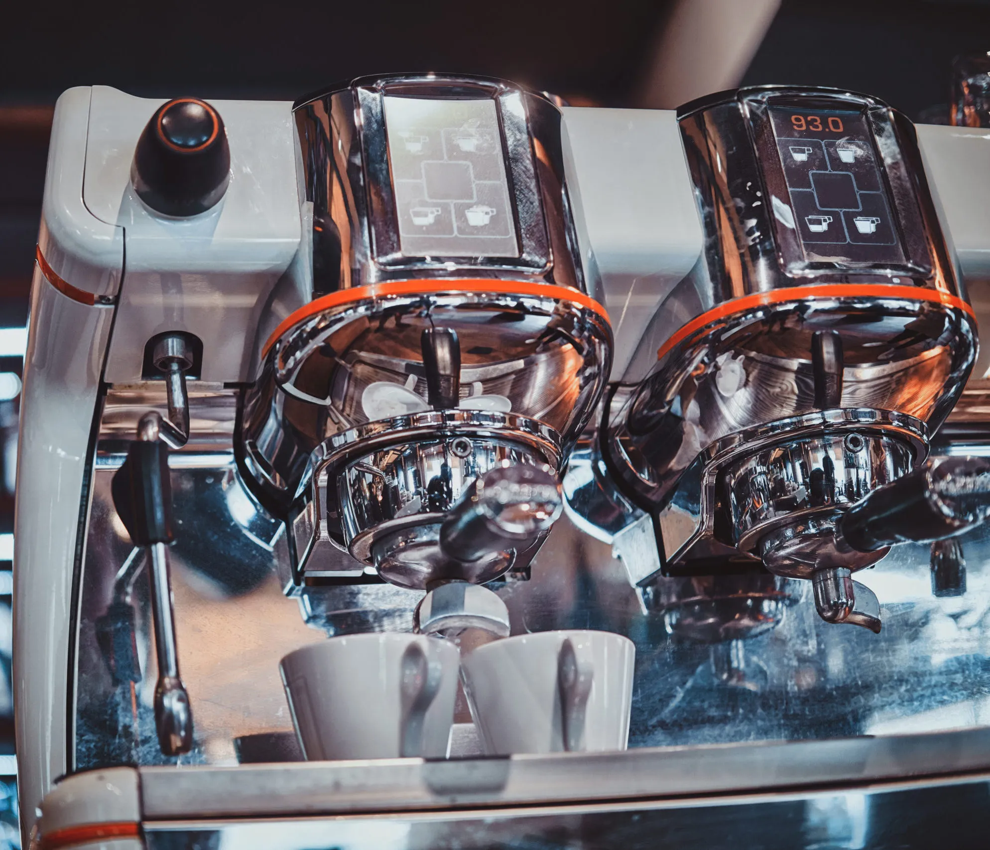 Polished commercial espresso coffee machine with cups ready for service in a cafe